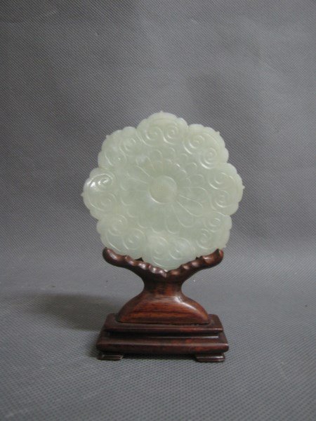 Good Chinese White/Grey Jade Button: of scalloped floriform, incised and decorated with petaled and jui head motifs, the whole set within a wooden stand, h 12cm Provenance: Mrs Betty Nelson Estate, Hong Kong 1947-1967