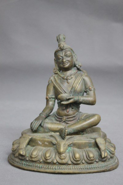 19th Century Bronze Milarepa Yogi,: depicted with head slightly tilted, wearing necklace holding a bowl in one hand and the other resting on knee, seated on goat rug on lotus base, accented with inlaid copper, h 16.5cm