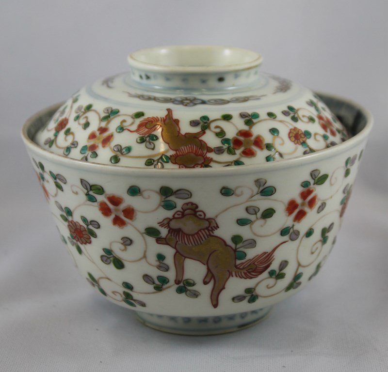Chinese Qing Dynasty, 19th Century, Porcelain Bowl: and Cover, decorated with three golden Buddhist lions, united by peony scroll in tones of green and iron red, the interior with blue and gilt decoration (rubbed), the lid with four character mark: lon