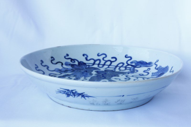 Chinese Early Qing Dynasty, Blue and White Charger: of circular form, with sloping sides, decorated with squirrel and grape vines, the exterior incised by hand with Chinese characters, d 28cm Provenance: Private Collection of Dr. Chung