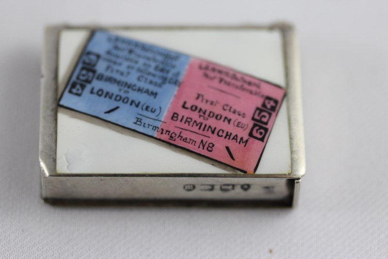 English Sterling Silver and Enamel Vesta Case,: of book form, the hinged top decorated with ticket, h 4cm