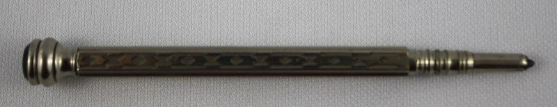 Edwardian Silver Propelling Pencil,: of facetted form, with engine turned motifs, set with a red stone finial, l 10cm