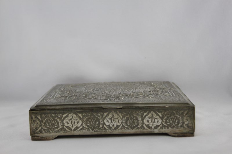 Iranian Silver Box and Cover,: of slender square form, the exterior decorated with central medallion surrounded by trailing flower heads, raised on four bracket feet, 16.cm x 16.5cm