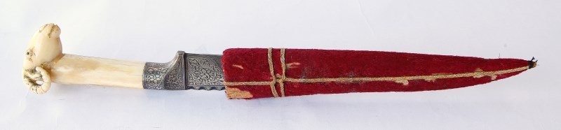 Indo-Persian Dagger (Khanjar),: slightly double curved damascus blade with ¾ serrated back, finely carved bone hilt in form of ram’s head, silver koftgari floral inlay to forte and part way down back of blade. l 28cm, l 30.5 cm (
