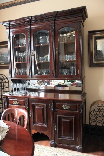 Late 19th Century Mahogany Sideboard,: molded cornice above dental frieze and three glazed doors enclosing shelves, flanked by pilasters above central cupboard door flanked by a short drawer and cupboard to each side, on plinth base, h 239