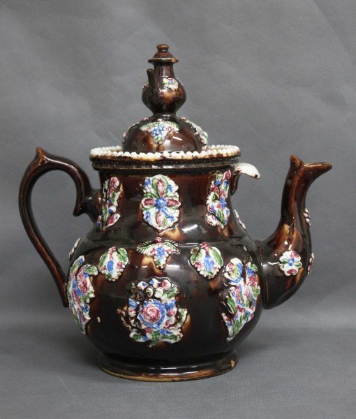 Large Victorian Bargeware Kettle: with a kettle finial, above a baluster body, decorated with raised floral groupings in tones of pink, green and blue, on a brown glazed ground, a/f, h 31cm