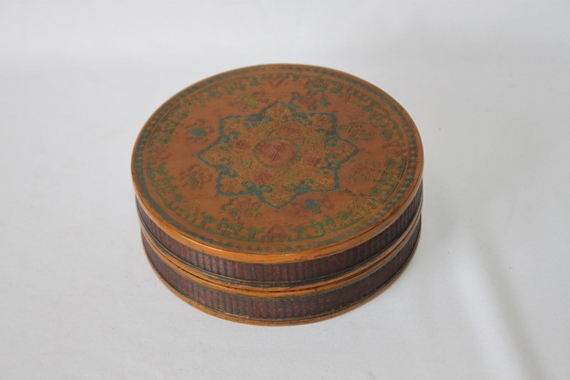 Chinese Cylindrical Box and Cover,: the cover decorated with a central shou symbol, surrounded by a star motif, the edges in the form of woven motif, in tones of brown, blue and gilt, d 18cm