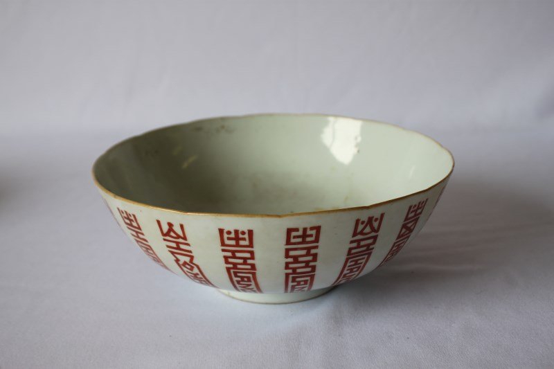 Chinese Porcelain Bowl,: with slight serpentine shaped edges, and biscuit coloured rim, the exterior decorated with shou motifs in iron red, on circular foot, with four character mark to base, on stand, d 22cm
