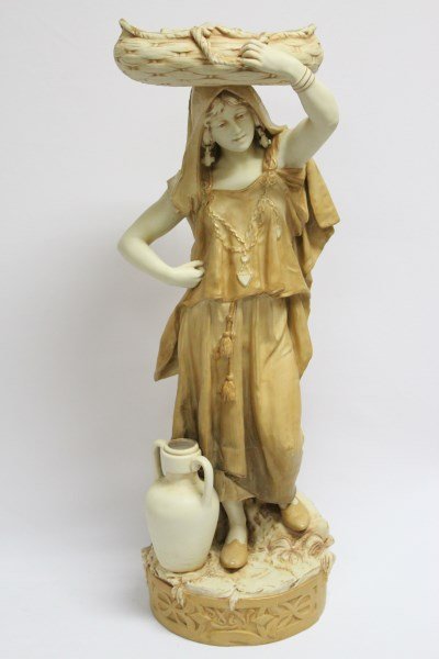 Royal Dux Porcelain Figure,: depicting a woman with amphora at her feet and carrying a basket aloft. with blush ivory finish, pink factory mark to base, h 65cm.