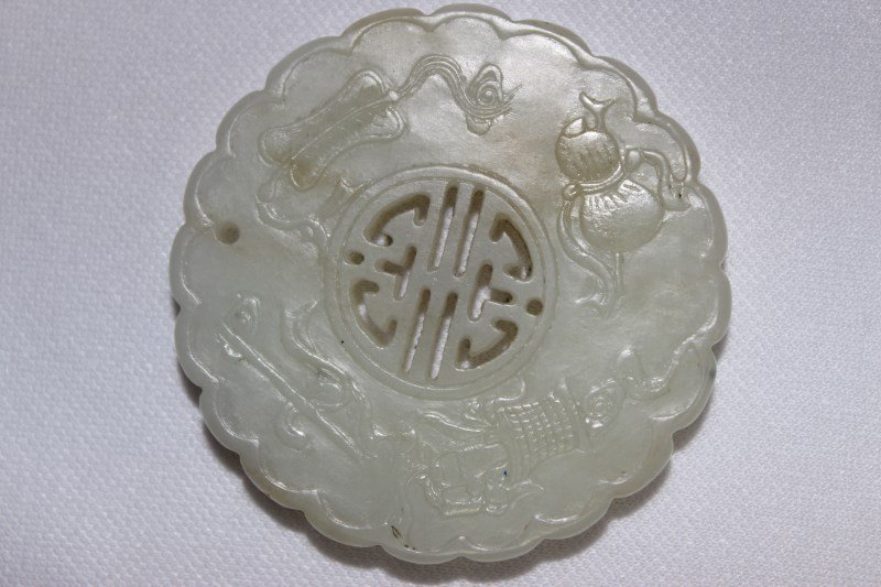 Chinese Carved Jade Disc,: of scalloped circular form, carved with the Buddhist precious items, d 5.5cm