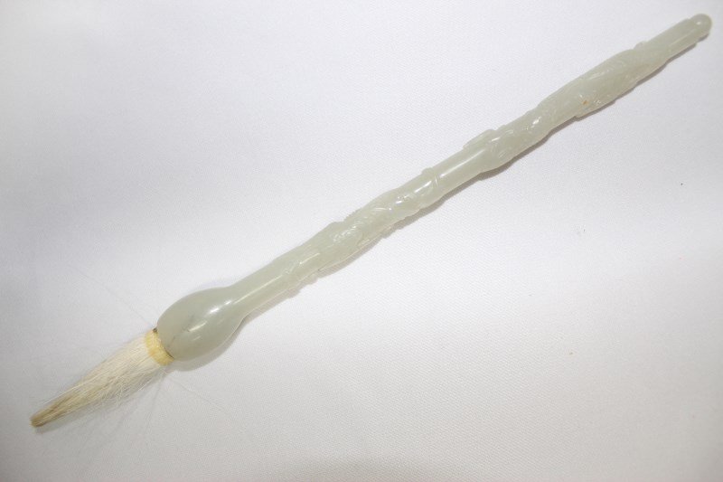 Chinese White Jade Calligraphy Brush,: of tapering form, carved with a raised dragon to the handle, l 18cm