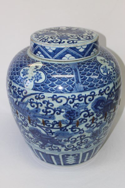 Large Chinese Porcelain Jar and Cover,: blue and white decorated central band depicting Phoenix and Guardian Lions on a flowering tendril ground, six character under glaze blue period mark to side, with extensive staple repair, h 44cm,