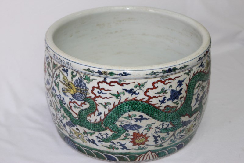 Chinese Porcelain Jardiniere,: with exterior decoration of a green and a red Dragon surrounded by flowering, leafy tendrils, with a six character mark to rim, in tones of red, green, blue and yellow, d 35cm h 22.5cm,