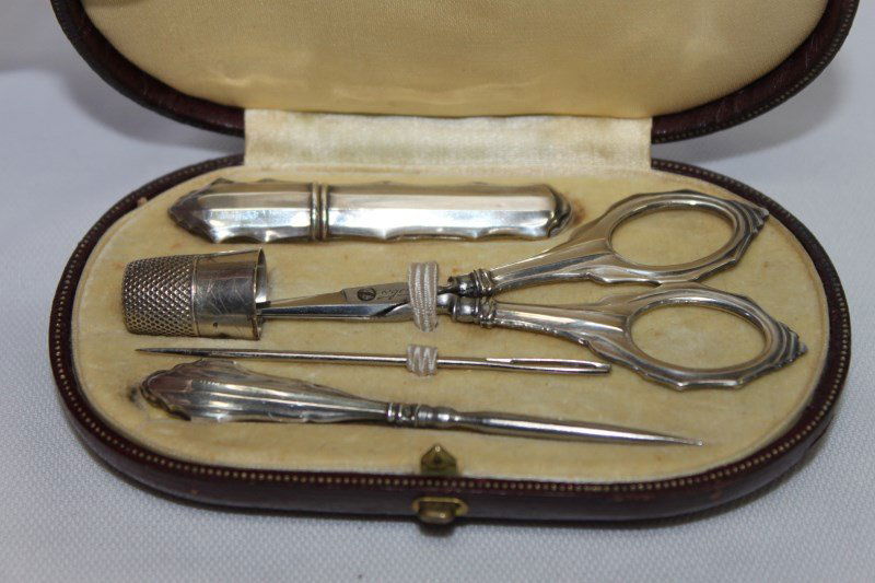 Cased Silver Sewing Set,: containing needle case, needle, scissors, awl and silver plated thimble,