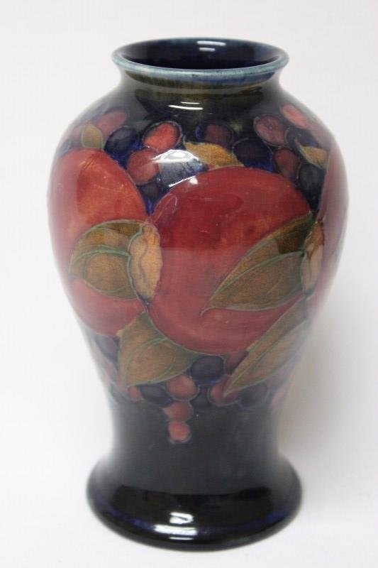 William Moorcroft Porcelain Vase, c.1925: of ovoid form, decorated with trailed pomegranates, berries and foliage in rich tones of coral, purple, cobalt and green, on circular foot, signed and impressed marks, h 16cm