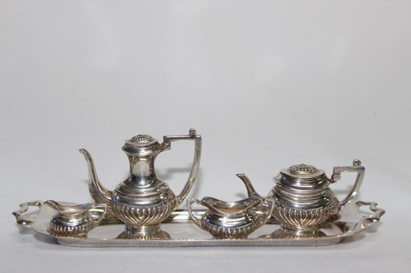 Miniature Silver Five Piece Tea Service,: hallmarked Birmingham, 1979, by William Adams Ltd. comprising tea pot, coffee pot, sugar bowl and cream jug together with a twin handled butlers tray, total weight 66gms, tray l 15cm (5)