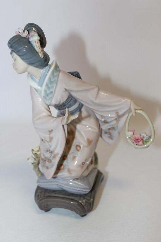 Lladro Porcelain Figure of Geisha,: depicted in robe holding a basket of flowers in tones of pink and purple, h 22cm