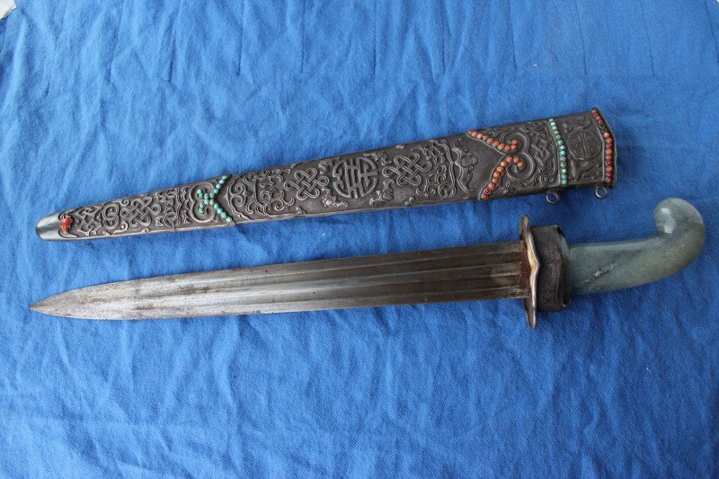 Superb 19th Century Chinese Short Sword,: with Jade Pistol grip hilt, a double edged twin fullered blade, the ornate silver scabbard with inlaid Turquoise and Coral beads and embossed decoration of Bats, Shou characters and Eternal Knots, l 4