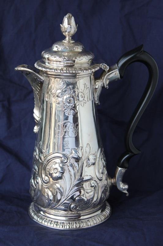 George II Sterling Silver Coffee Pot,: hallmarked, London, 1750, Phillips Garden, of tapering form, with bud finial and s-scroll ebony handle, the body decorated with c-scrolls, flower heads and petit armorial, raised on spreading gadroone