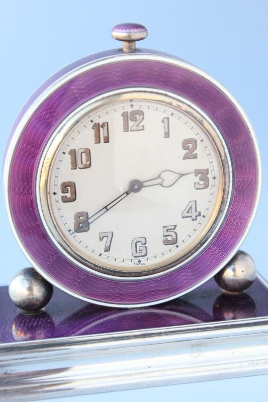 Art Deco Silver and Enamel Bedside Alarm Clock,: silver clock marked '935', with circular clock flanked by silver balls on a low stepped silver base, enameled in deep purple with white trim, mechanism requires service, h 8.5cm