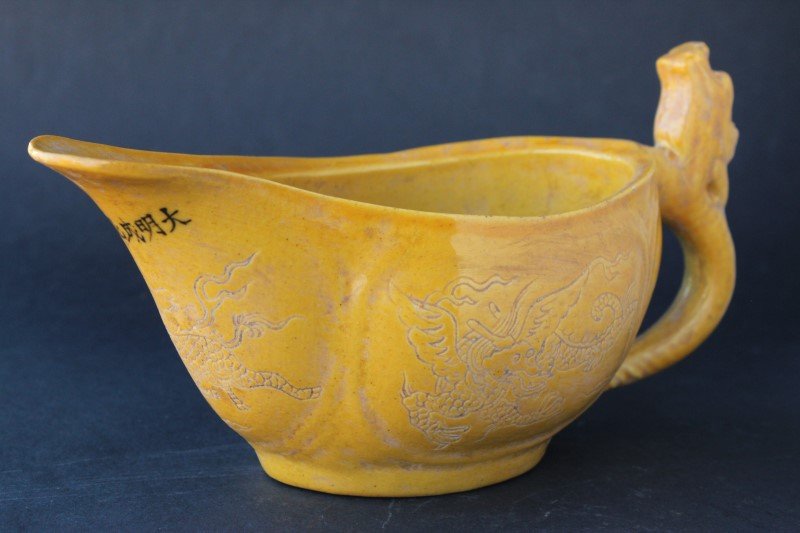 Chinese Yellow Glazed Sauce Boat,: with a dragon head thumb piece to handle, the body decorated with incised dragons, six character mark to lip, l 19cm
