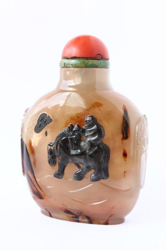 Chinese Agate Snuff Bottle and Stopper,: flattened ovoid agate bottle with twin stylised ring handles to shoulders, carved with monkey riding a horse, coral stopper, h 7.5cm