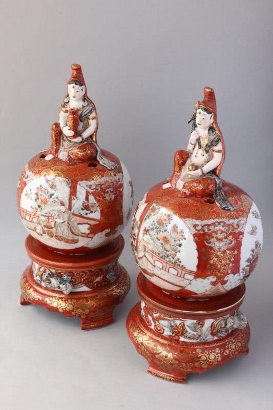 Pair of Japanese Kutani Censors and Stands,: the finials in the form of buddhas, holding attribute, seated upon spherical bodies decorated with reserves of figures, surrounded by scroll work, on a cylindrical base, decorated with raised dragon, 