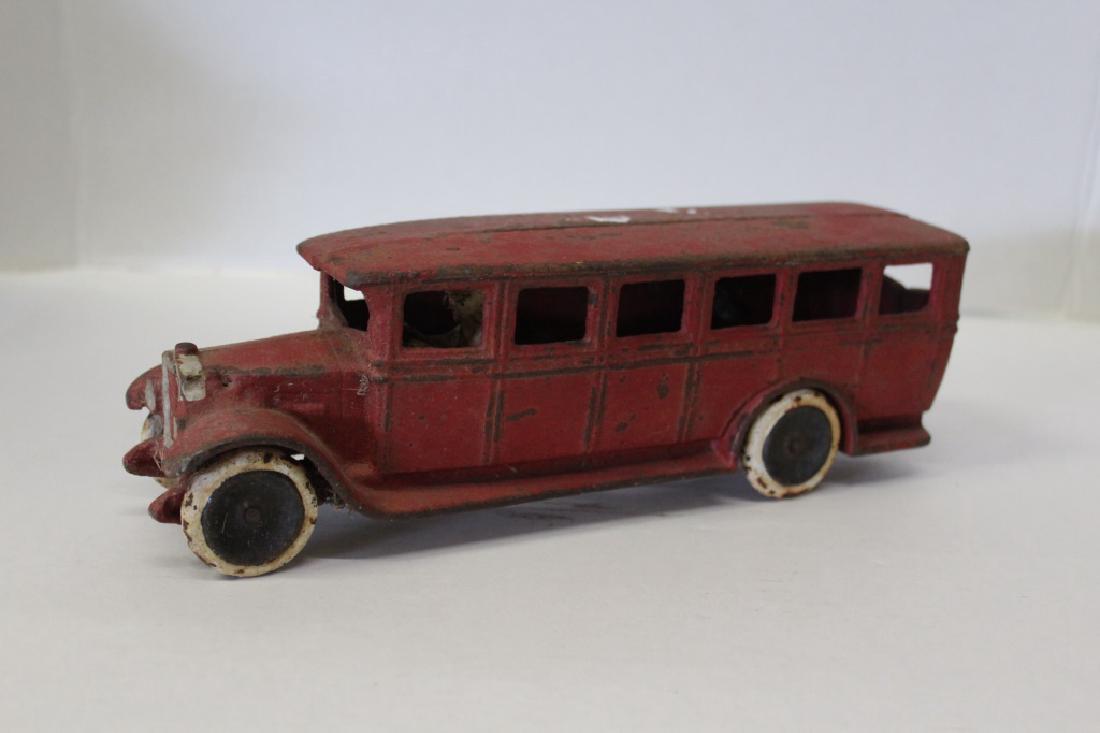Skoglund & Olson Bus Toy: Cast iron toy of a bus by Skoglund & Olson. Red bus with a driver inside. Marked. Measures approximately 3" High, 10.5" Wide and 3" Deep. Good condition.