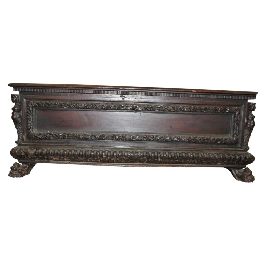 Antique Figural Carved Chest w/ Key: Figural carved antique chest. Features strap hinges and carved figures on each corner with claw feet and dental molded top. This piece has its original key. Measures approximately 22.5" High, 60.25" W