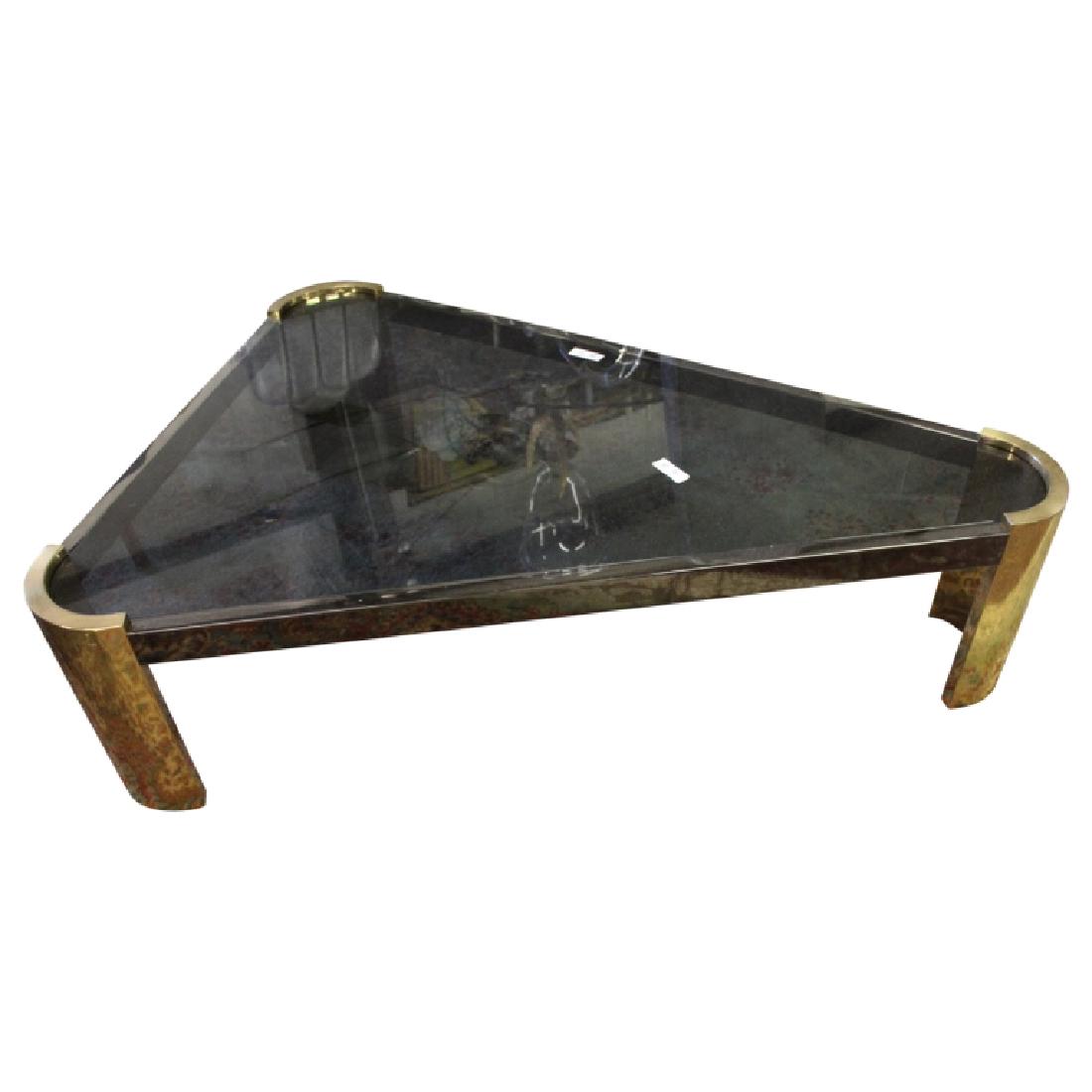 Jay Spectre Coffee Table: Jay Spectre coffee table in the triangular shape. The design features a black glass top and gold end caps. Measures approximately 60.5" Long, 44" Wide and 16.5" High. Good condition.