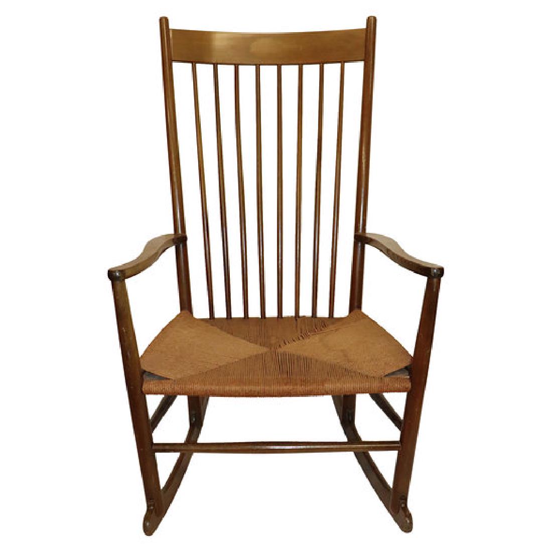 Hans Wegner Style Rocking Chair Signed: Hans Wegner Style Rocking Chair with Rush Seat. Measuring 40 inches tall by 20 inches deep and 23 inches wide. Chair is in very good condition. Slight discoloration to rush.Stamped: Made in Denmark