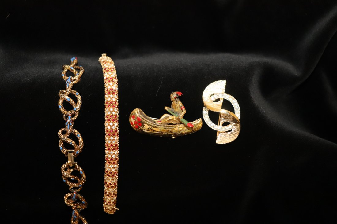 4 Pieces of Great Costume Jewelry: Nice collection of costume jewelry. One twisted rope style bracelets with gold and blue stones one of the links needs attention. Bracelet with red and clear stones clasp marked Ciner. A pin with Canoe