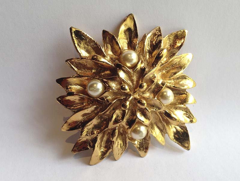YVES-SAINT-LAURENT. Broche: Metal dorte. motif de fleur, 4 perles Poincon