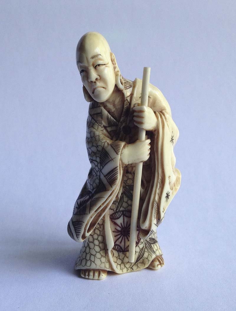 Japon, XIXe. Netsuke Â«PrÃªtre s'appuyant sur son: Japon, XIXe Netsuke Â«PrÃªtre s'appuyant sur son baton Ivoire sculpte, teinte dans les creux et signe Haut. 6,2 cm.