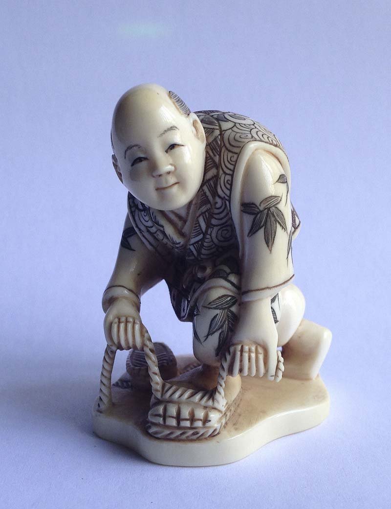 Japon, XIX-XXe. Netsuke Personnage lacant ses: Japon, XIX-XXe Netsuke Personnage lacant ses sandales Ivoire sculpte, teinte dans les creux et signe Haut. 5,3 cm.