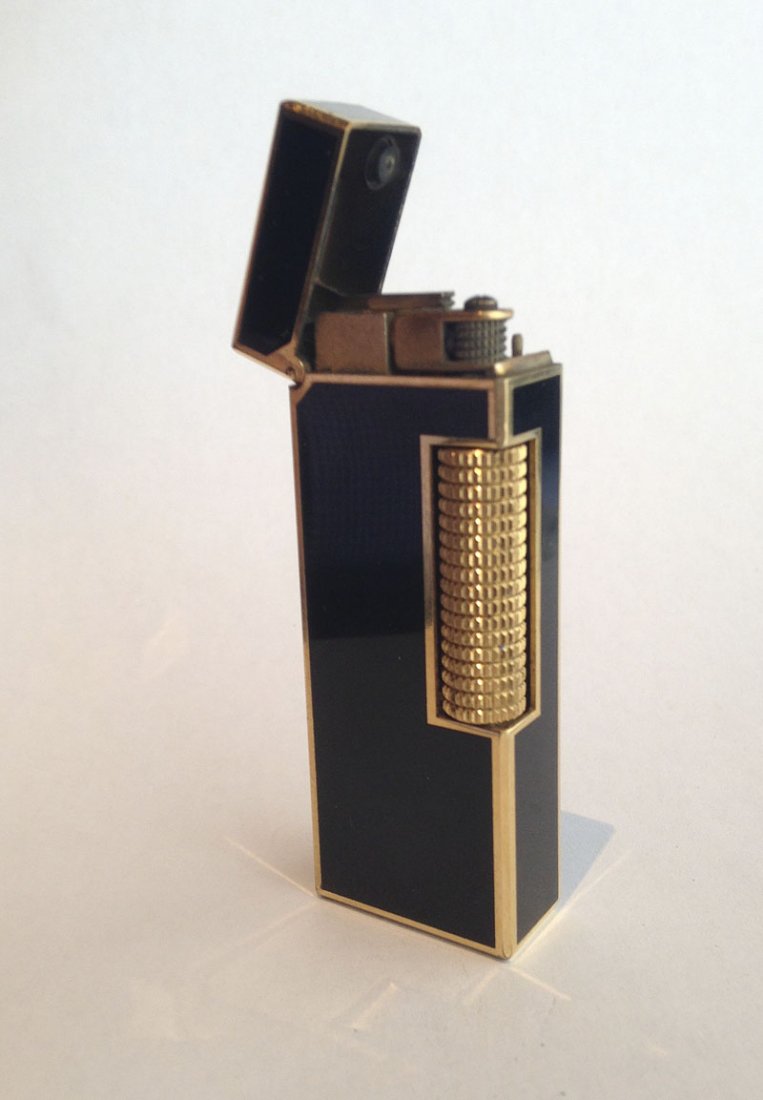 DUNHILL. Briquet: DUNHILL Briquet Laque noire et métal plaqué or, petites usures, fonctionne Haut.6,5 cm.