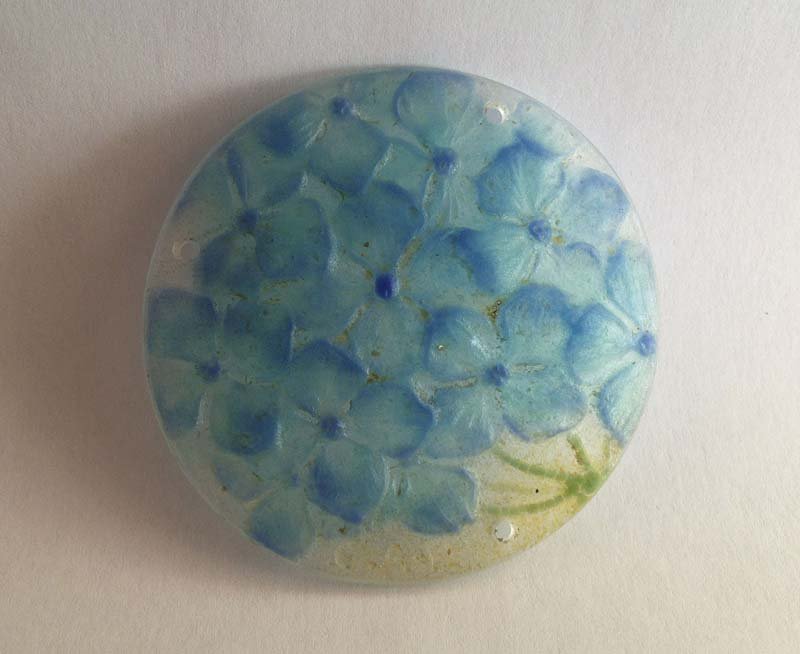 ARGY-ROUSSEAU Gabriel (1885-1953). Pendentif rond aux: ARGY-ROUSSEAU Gabriel (1885-1953) Pendentif rond aux fleurs PÃ¢te de cristal quatre tons, dominante bleu turquoise, decor en ronde-bosse Signe dans la pÃ¢te G.A-P Diam. 6,3 cm.