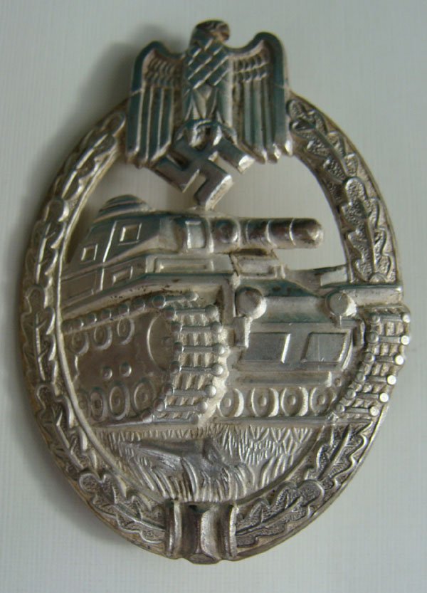 WWII German Panzer Badge: WWII German Panzer Badge. "Frosted" silver tank within an oak leaf wreath. Hollow reverse.
