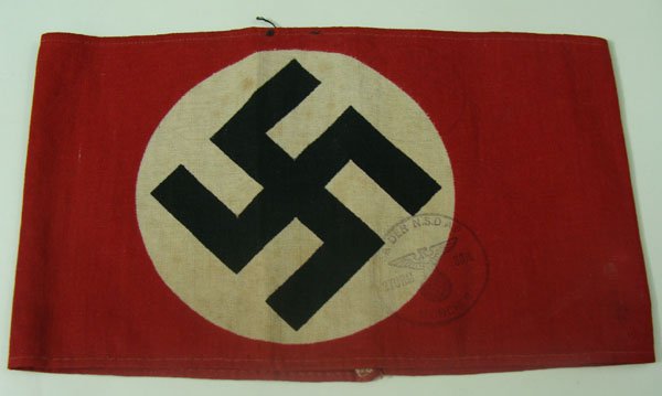 German NSDAP member armband: German NSDAP member armband. A 36cm x 11cm red cotton armband, upon which is sewn an approximately 9cm diameter white, cotton disk, with a black, cotton tape mobile swastika sewn to it. Faint NSDAP pr