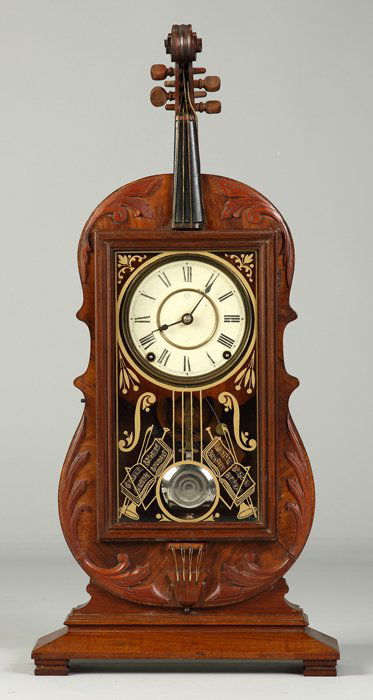 Fine and Rare Seth Thomas Violin Clock: Walnut case with applied and carved trim and nice old, possibly original, finish. The case is stamped on reverse, 58811. Original glass. Original signed Seth Thomas dial. 8 day time and strike lyre mo