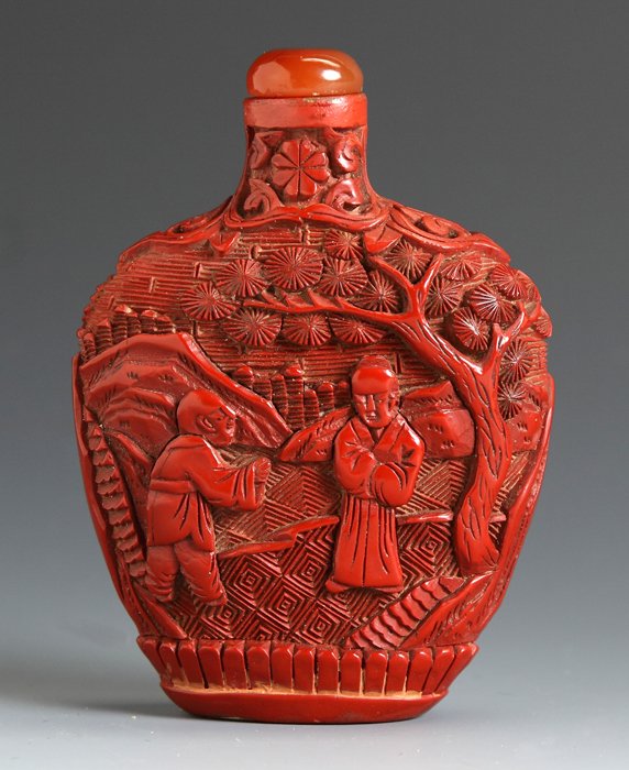 Cinnabar Snuff Bottle: Cinnabar Snuff Bottle. Flattened spade shaped bottle, relief carved decoration of elders & child. Ht. 2 7/8".