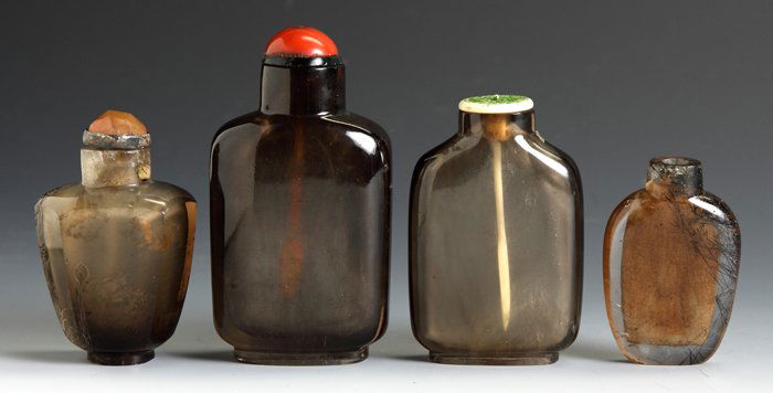 Three Smokey Quartz and One Hair Crystal Snuff Bottles: Three Smokey Quartz and One Hair Crystal Snuff Bottles. Smokey Quartz, flattened spade shaped, etched flowers , Ht. 2 1/2"; Smokey Quartz, Straight sided flattened flask, Ht. 3 1/4"; smoky Quartz Stra