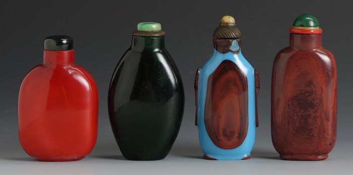 4 Cased Glass Snuff Bottles: 4 Cased Glass Snuff Bottles. Round flattened flask, Ht. 2 3/4"; Ovate flattened flask, Ht. 3"; Blue and red overlaid Glass, ovate flattened flask with foo dogs, some chips, Ht. 3"; Straight sided flat