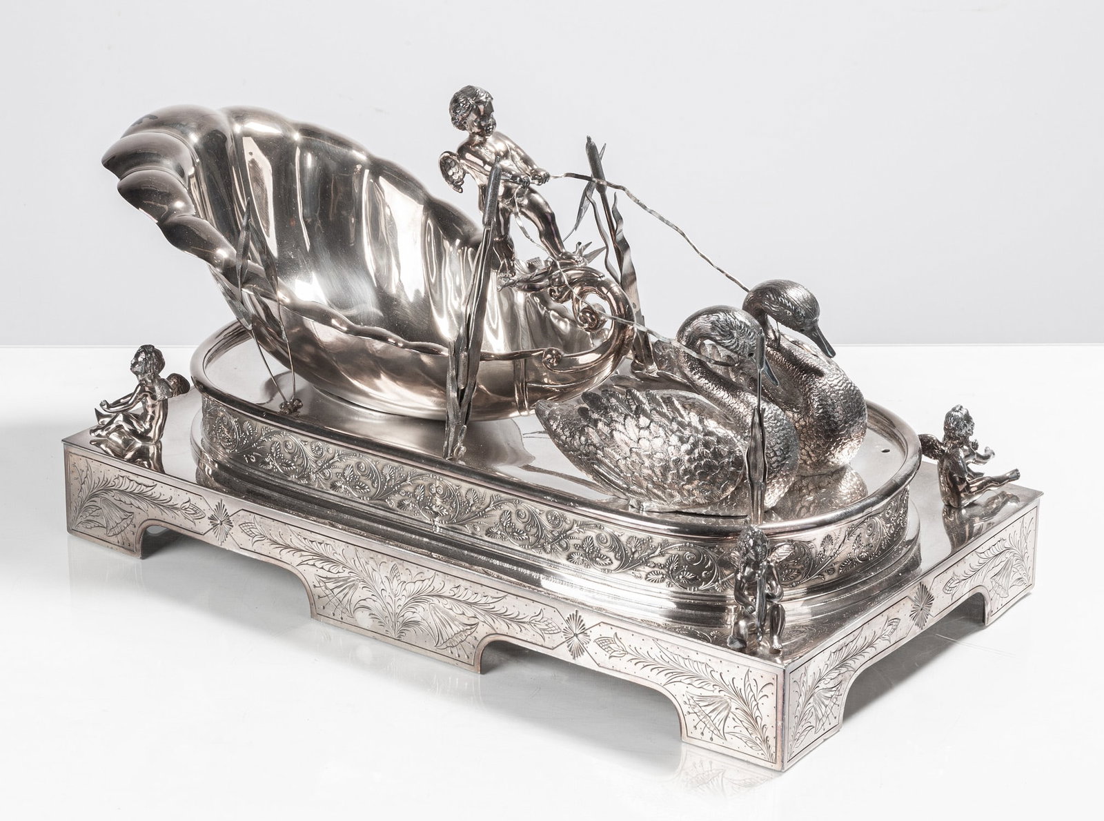 The Barge of Venus Electroplate Centerpiece: The Barge of Venus Electroplate Centerpiece Designed 1876 by the Middletown Silver Plate Co., Middletown, Connecticut. The large rectangular plinth base is engraved with flowers and fitted with a larg
