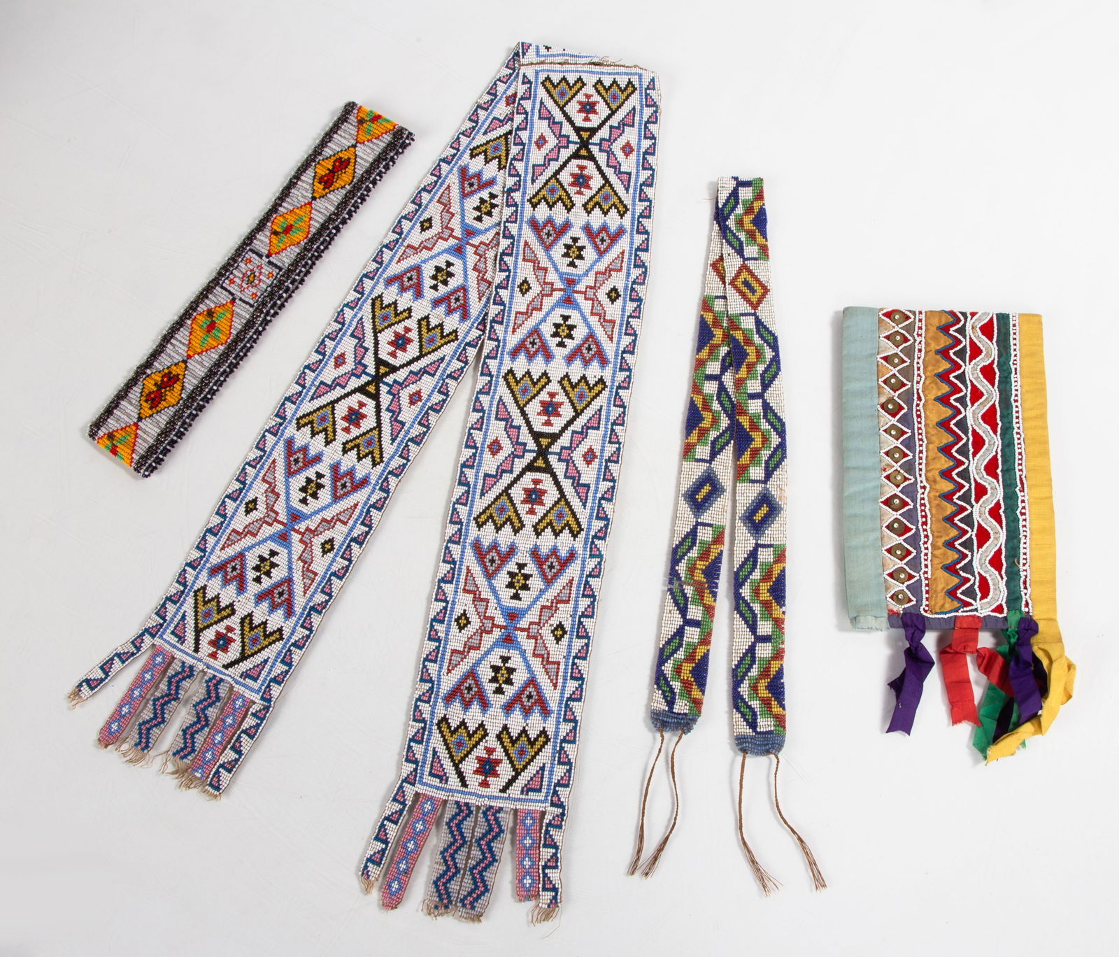 Four Native American Beaded Sashes / Headband: Four Native American Beaded Sashes / Headband Early 20th century. Max L. 40 in. Shipping Note: We provide our own in-house shipping service; separate from LiveAuctioneers. Please reach out to us