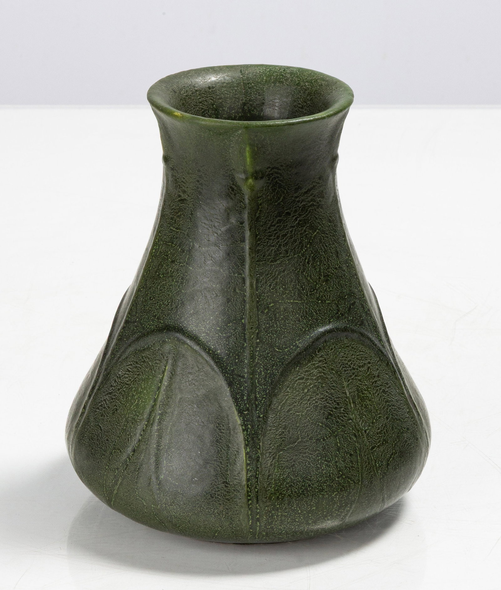 Grueby Tooled-Leaf Matte Green Vase: Grueby Tooled-Leaf Matte Green Vase Boston, Massachusetts, circa 1910. Glazed earthenware. Impressed circular Grueby lotus mark to underside; incised EIVK (to the underside). Ht. 6 3/4 in. The collect