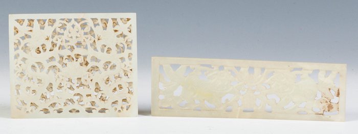 Two Carved Jade Plaques: Two Carved Jade Plaques. Both pierce carved. L: floral design, Ht. 2 3/4" W 3 1/4" & R: foo dogs, small fracture, Ht. 1 1/2" W 5". .