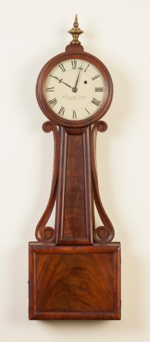 Nehemiah Dodge Wood Front Banjo Clock: Nehemiah Dodge Wood Front Banjo Clock. Figured mahogany case, old finish. Original painted metal dial, signature strengthened. 8 day time only weight driven brass movement; back plate of mvt. stamped