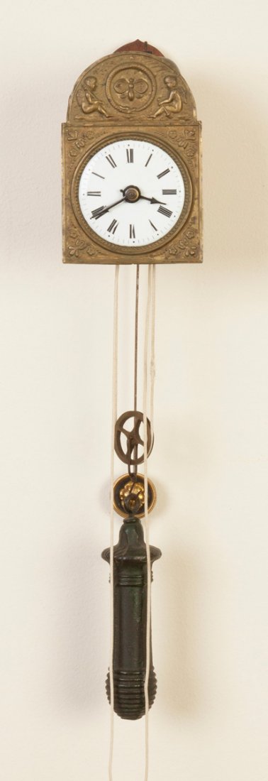 Miniature Black Forest Wag-on-Wall Clock: Miniature Black Forest Wag-on-Wall Clock. Putti foil mask. Porcelain dial. Time & strike movement. Ht. 4 1/2" W 3". The Henderson Collection, Maryland.