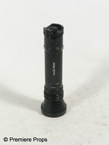 Resident Evil Afterlife Hero Flashlight Movie Prop: Resident Evil Afterlife - Hero black metal with white 'Fenix TK40,' twist bottom silver head flashlight. (approx. 8 1/2" long) Working condition unknown. Condition may vary slightly.